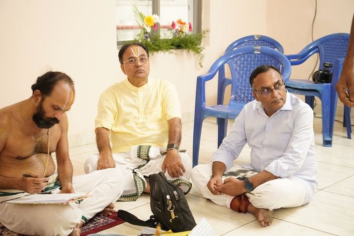 Priest and family members seated during the ceremony